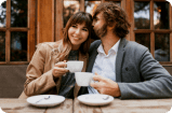 two people at the table with cups