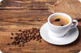 coffee beans next to a cup of coffee
