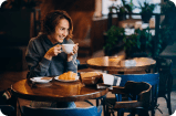 woman at table with coffee and croissant
